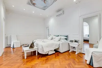 a white bedroom with a bed and a table at New opening Spagna Suite in Rome
