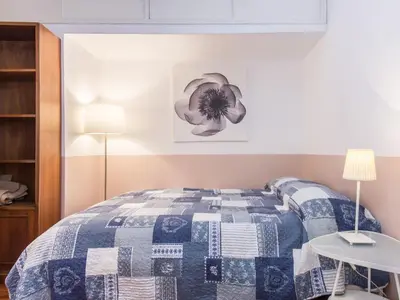 a bedroom with a bed with a blue and white quilt at Spacious 2BR in the historic center in Rome