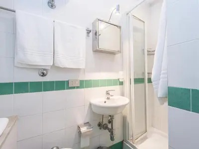 a white bathroom with a sink and a mirror at Spacious 2BR in the historic center in Rome