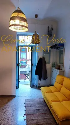 a living room with a yellow couch in a room at Come' Na Vorta Apartment in Rome