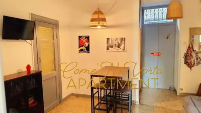 a dining room with a table and a sign on the wall at Come' Na Vorta Apartment in Rome