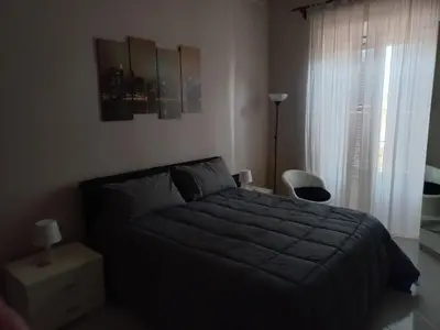 a bedroom with a black bed and a window at tommy's house in Rome