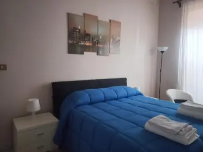 a bedroom with a blue bed with a blue blanket at tommy's house in Rome