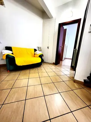 a living room with a couch with a yellow blanket at Da Zia Elena in Rome