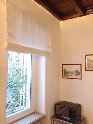 a window with a white curtain and a television at NAVONA, Old Rome Lodge in Rome