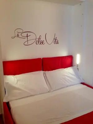 a bed with a red headboard with a sign that reads i dance viz at NAVONA, Old Rome Lodge in Rome