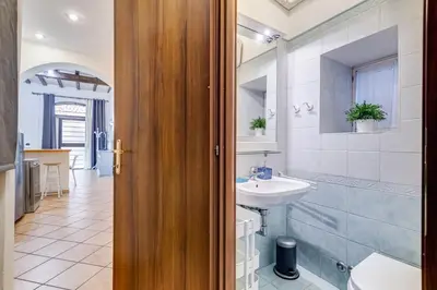 a bedroom with a large bed and a kitchen at Coliseum Rome Apartments in Rome
