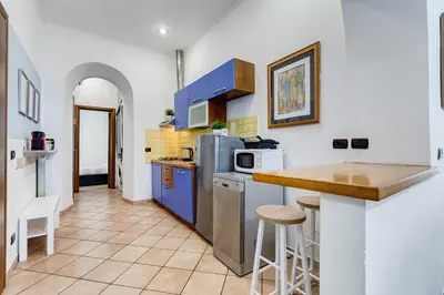a white bedroom with a bed and a mirror at Coliseum Rome Apartments in Rome