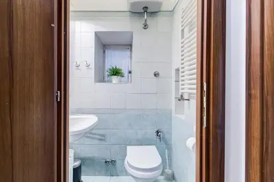a bedroom with a large bed with white sheets at Coliseum Rome Apartments in Rome