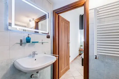 a bathroom with a sink and a toilet and a mirror at Coliseum Rome Apartments in Rome
