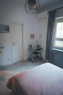 a bedroom with a bed and a table and a window at Urban House Monteverde in Rome