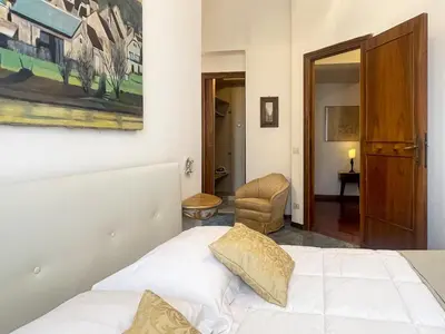 a bedroom with a white bed and a chair at La Casa di Pina in Rome