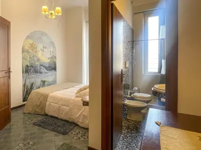a bedroom with a bed and a bathroom with a toilet at La Casa di Pina in Rome
