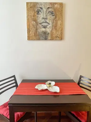 a table with a red blanket and a painting on the wall at La Casa di Pina in Rome