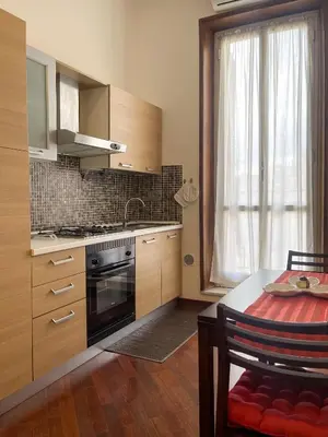 a kitchen with a stove and a sink and a table at La Casa di Pina in Rome
