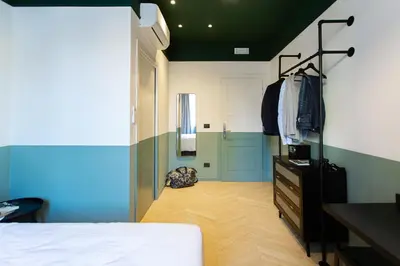 a bedroom with a bed and a dresser in a room at Saint Suites in Rome
