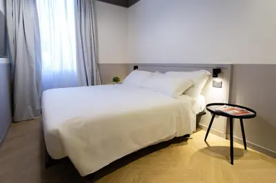 a bedroom with a large white bed and a table at Saint Suites in Rome