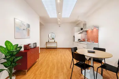 a living room with a table and a kitchen at Lungotevere Trastevere Loft in Rome
