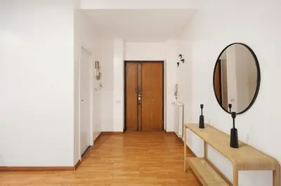 a hallway with a mirror and a wooden door at Lungotevere Trastevere Loft in Rome