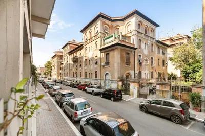 a street with cars parked in front of a building at Lungotevere Trastevere Loft in Rome