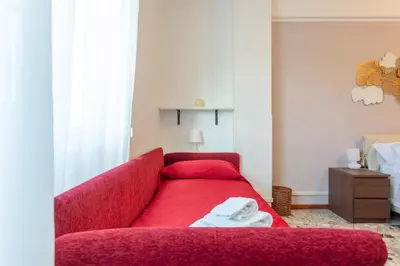 a red couch sitting in a living room with a table at Casina Soleggiata in Rome
