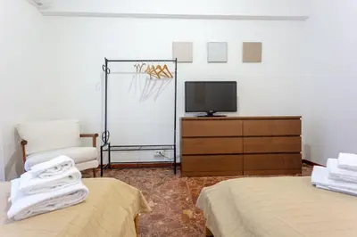 a bedroom with two beds and a tv and a chair at Casina Soleggiata in Rome
