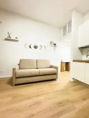 a couch in a living room with a wooden floor at Vaschome in Rome