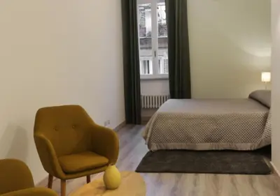 a bedroom with a bed and a chair next to a window at Centro Roma Verde - LOCAPPART in Rome