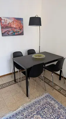 a black dining room table with chairs and a lamp at Eleganza e stile Capitolino in Rome