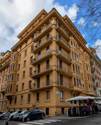 a large yellow building with cars parked in front of it at Eleganza e stile Capitolino in Rome