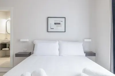 a bedroom with a white bed with white pillows at Belli San Giovanni Guest House in Rome