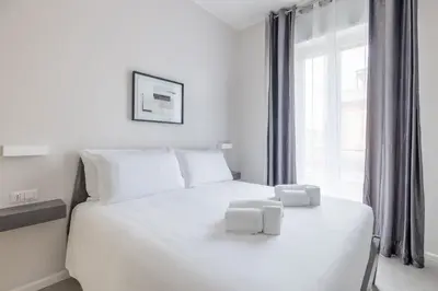 a bedroom with a white bed with two towels on it at Belli San Giovanni Guest House in Rome