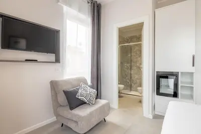 a living room with a chair and a television at Belli San Giovanni Guest House in Rome