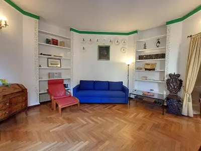 a living room with a blue couch and a red chair at la casa del Duca a Monti in Rome