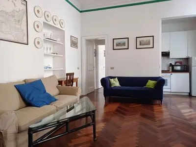 a living room with a couch and a blue chair at la casa del Duca a Monti in Rome