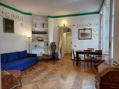 a living room with a blue couch and a table at la casa del Duca a Monti in Rome