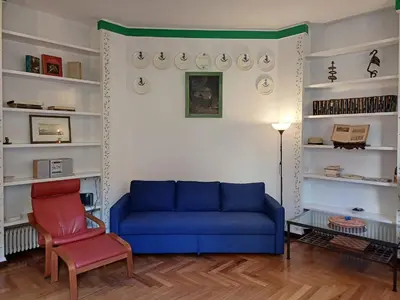a living room with a blue couch and a chair at la casa del Duca a Monti in Rome