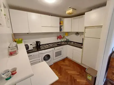 a small kitchen with white cabinets and a dishwasher at la casa del Duca a Monti in Rome