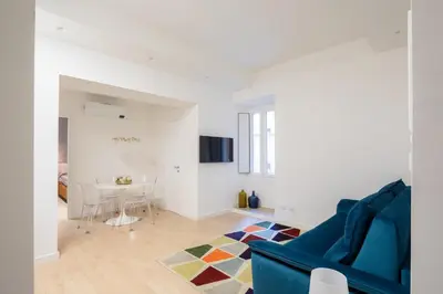 a living room with a blue couch and a table at Giulio Cesare Flat - VATICAN in Rome