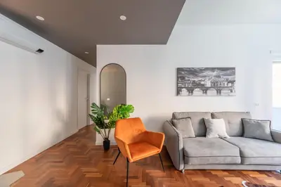 a living room with a couch and a chair at Skylife Modern 4-Bedroom Trastevere Apartment in Rome