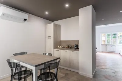 a kitchen with a table and chairs in a room at Skylife Modern 4-Bedroom Trastevere Apartment in Rome
