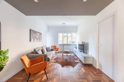 a living room with a couch and a tv at Skylife Modern 4-Bedroom Trastevere Apartment in Rome