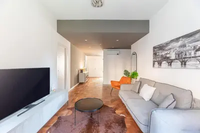 a living room with a couch and a flat screen tv at Skylife Modern 4-Bedroom Trastevere Apartment in Rome