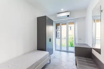 a bedroom with a bed and a window with a balcony at Skylife Modern 4-Bedroom Trastevere Apartment in Rome