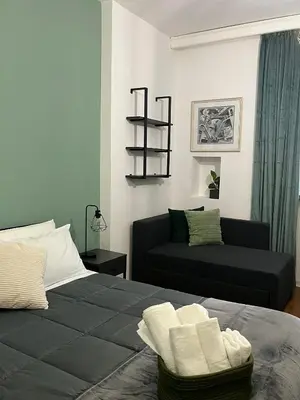 a bedroom with a black bed and a couch at RiversideMellini44 in Rome