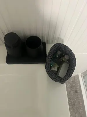 a black container on a white wall with a cup at RiversideMellini44 in Rome