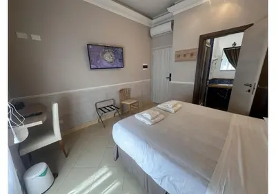 a bedroom with a white bed with a painting on the wall at Spqr Suite Guest House in Rome