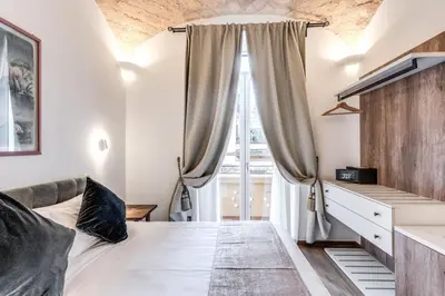 a bedroom with a bed and a large window at Rose Inn Guest House in Rome