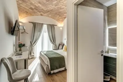 a bedroom with a bed and a desk and a chair at Rose Inn Guest House in Rome