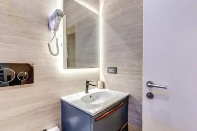 a bathroom with a sink and a mirror at Rose Inn Guest House in Rome
